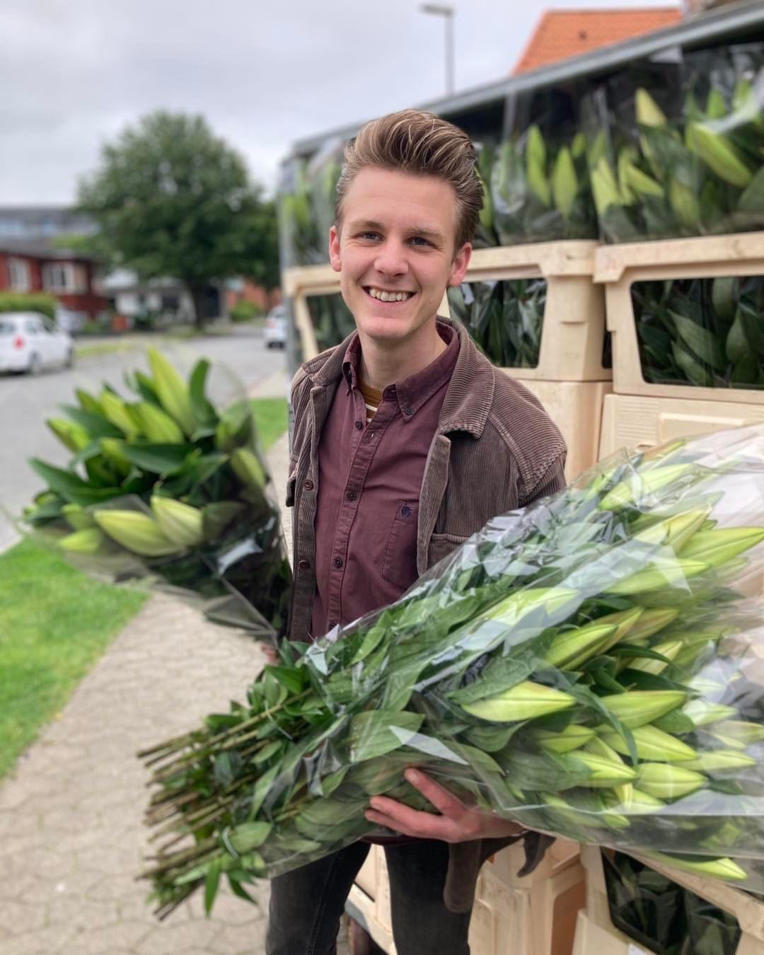Hænder der holder mobiltelefon og tager billede af blomster